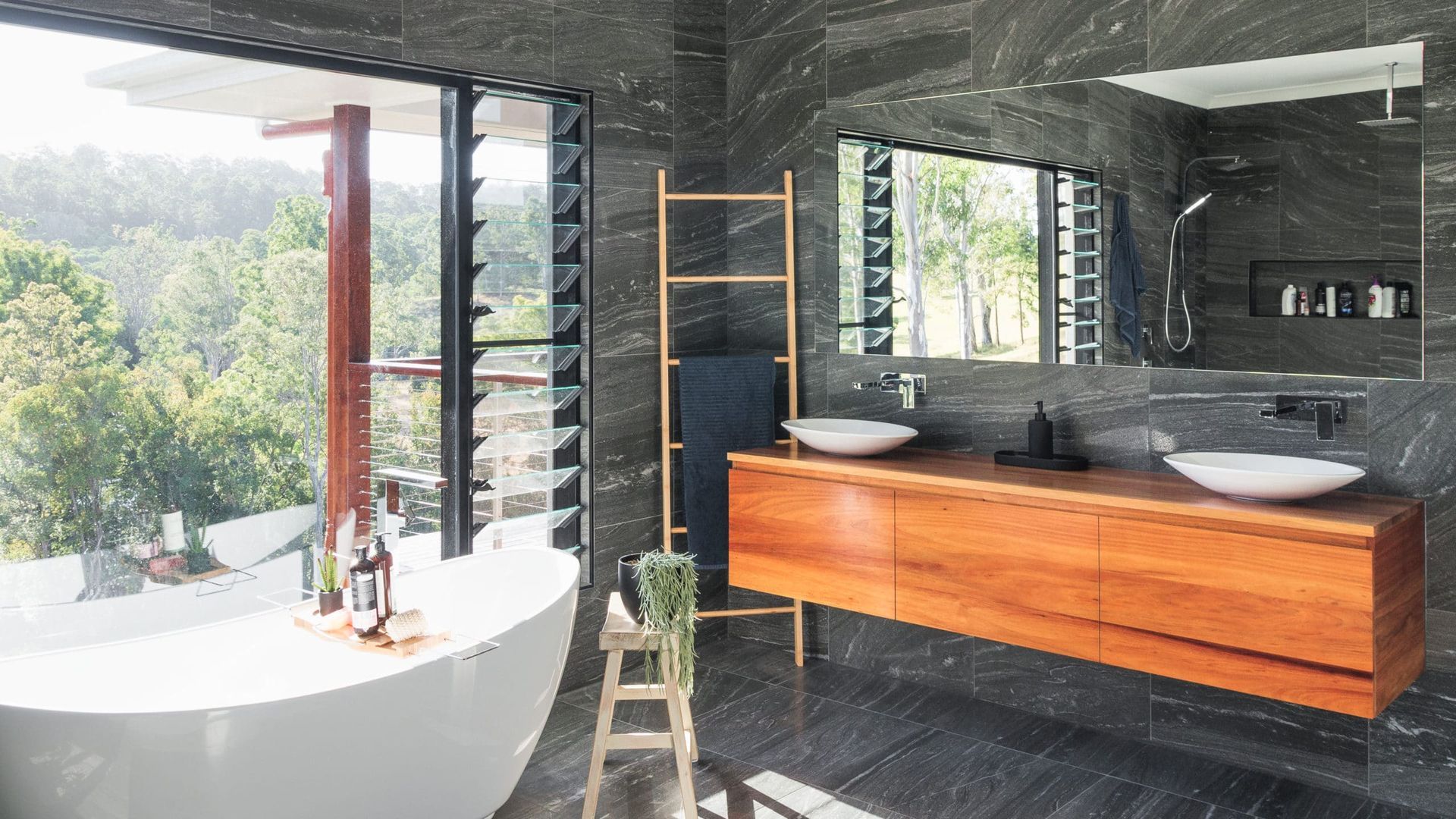 Luxurious Bathroom With Soaking Tub, Wooden Vanity, and Large Windows Overlooking a Forest — Akyrah Kitchens in Gympie, QLD