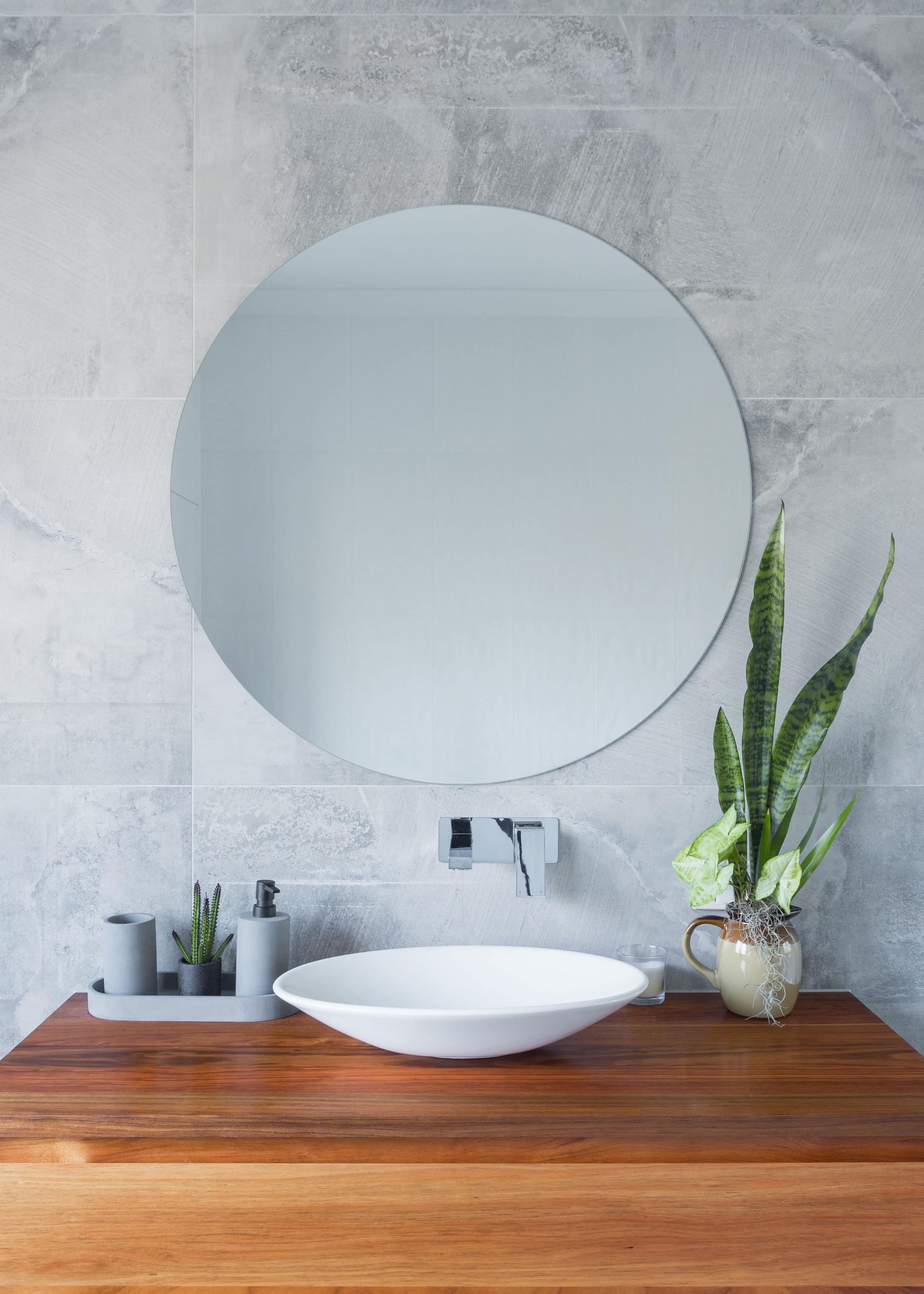 Bathroom With Wooden Countertop, Round Mirror, White Sink, and Plant — Akyrah Kitchens in Gympie, QLD