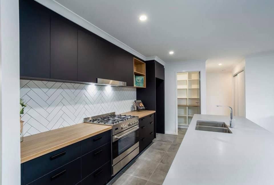 Modern Kitchen With Black Cabinets, Wooden Countertops, and a Long White Countertop Island — Akyrah Kitchens in Gympie, QLD