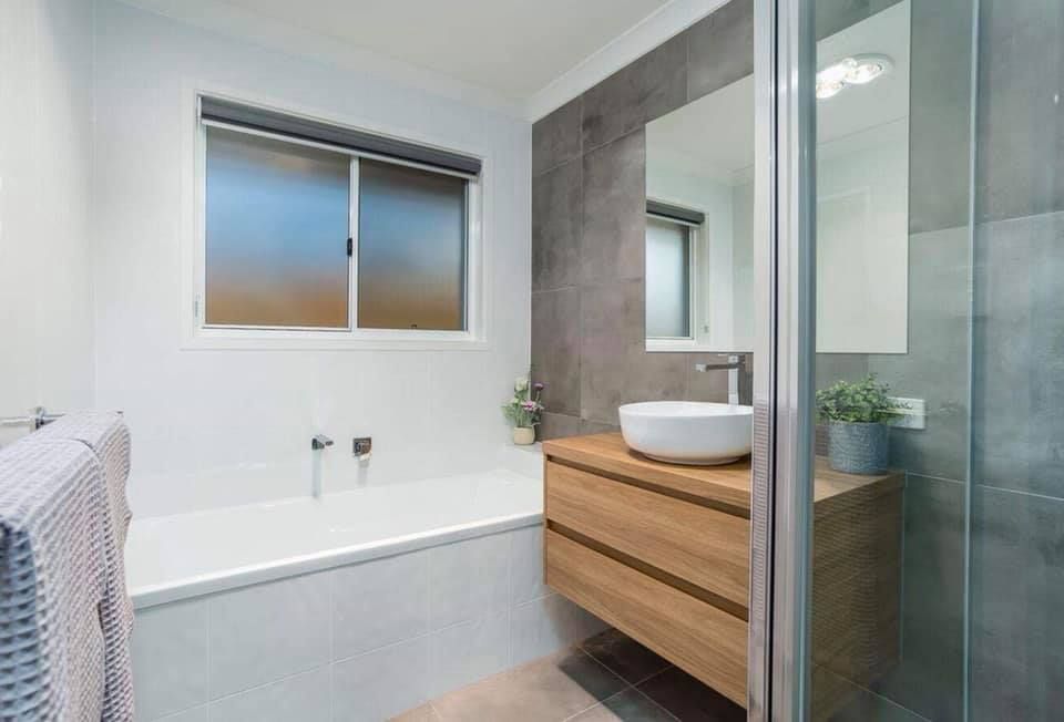 Modern Bathroom With White Walls, Wooden Vanity, and a Gray Shower — Akyrah Kitchens in Gympie, QLD