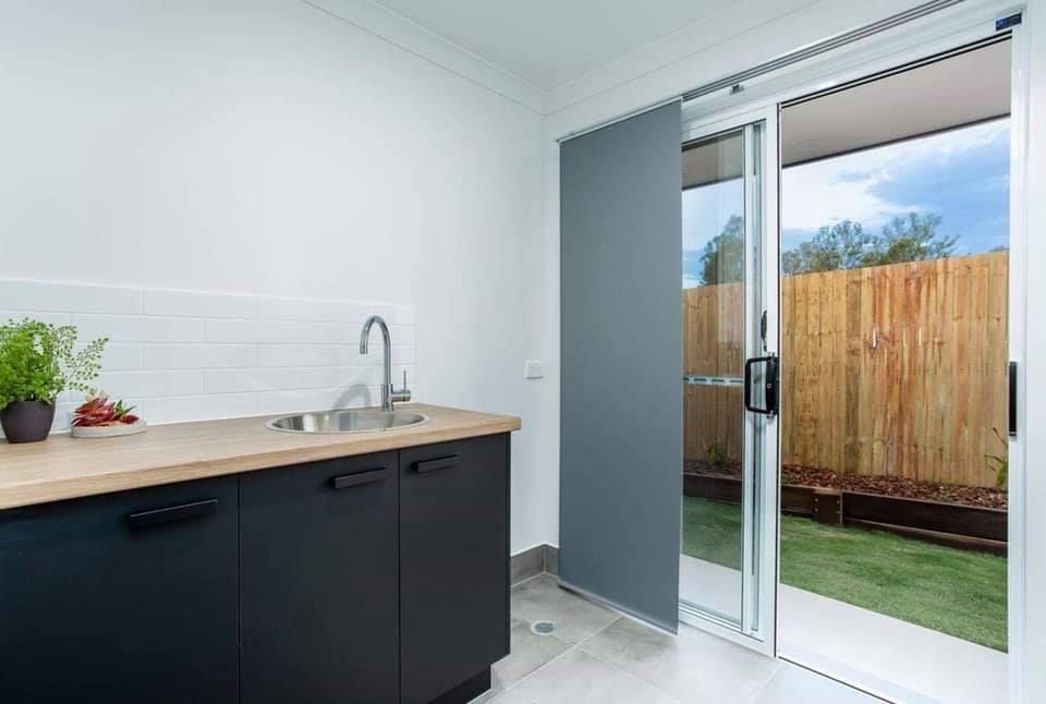 Laundry Room With Sink, Cabinets, and Sliding Glass Door to Backyard — Akyrah Kitchens in Gympie, QLD