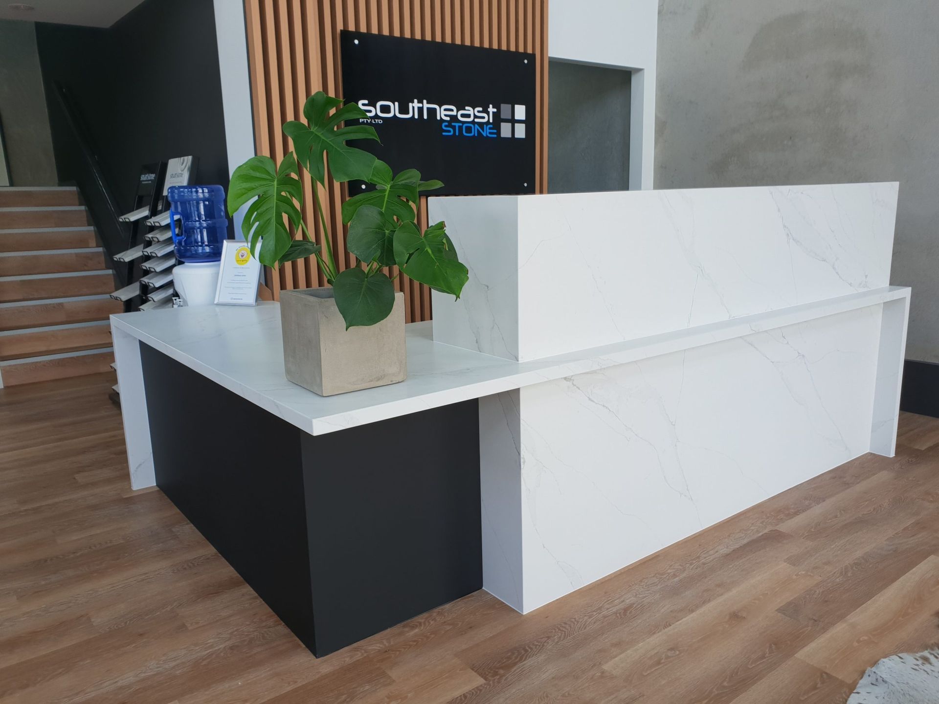 Modern Reception Desk With White and Black Finish, and Stairs in the Background — Akyrah Kitchens in Gympie, QLD