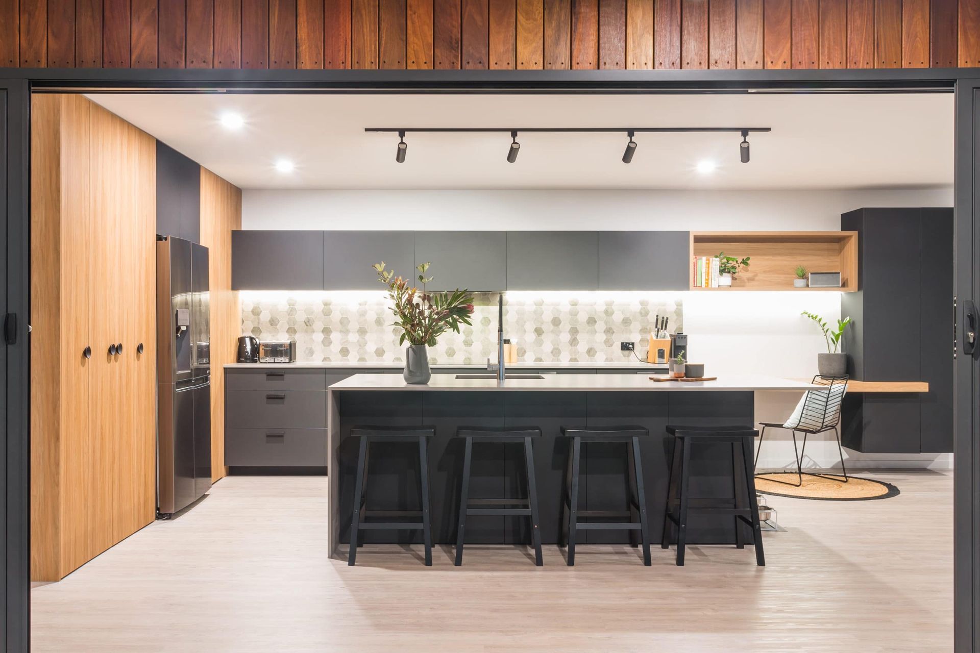 Modern Kitchen With Island, Black Cabinets, Wood Accents, and Bar Stools — Akyrah Kitchens in Gympie, QLD
