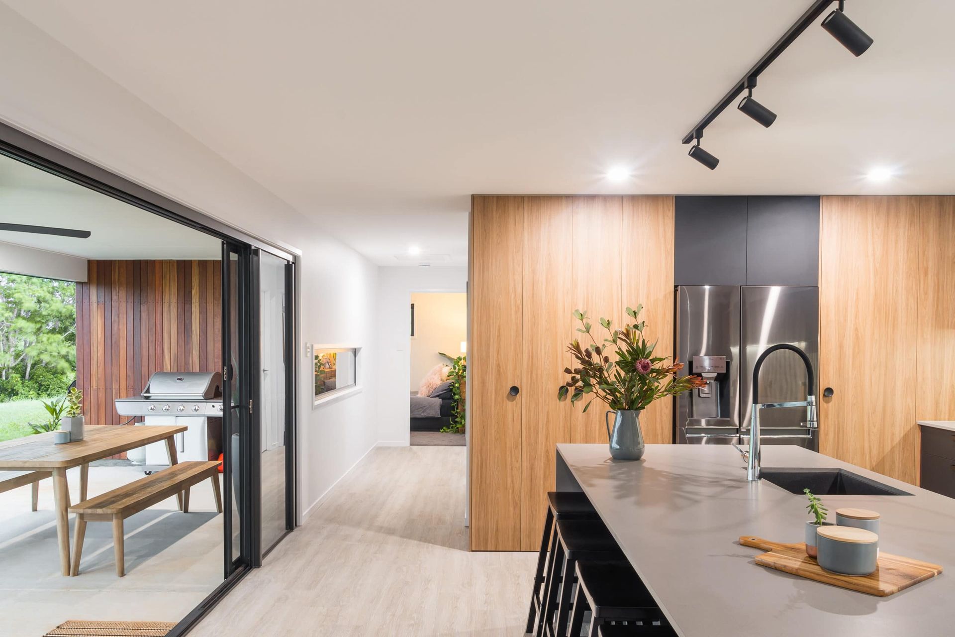 Modern Kitchen With Light Wood Cabinets, Gray Countertops, and a Sliding Glass Door — Akyrah Kitchens in Gympie, QLD