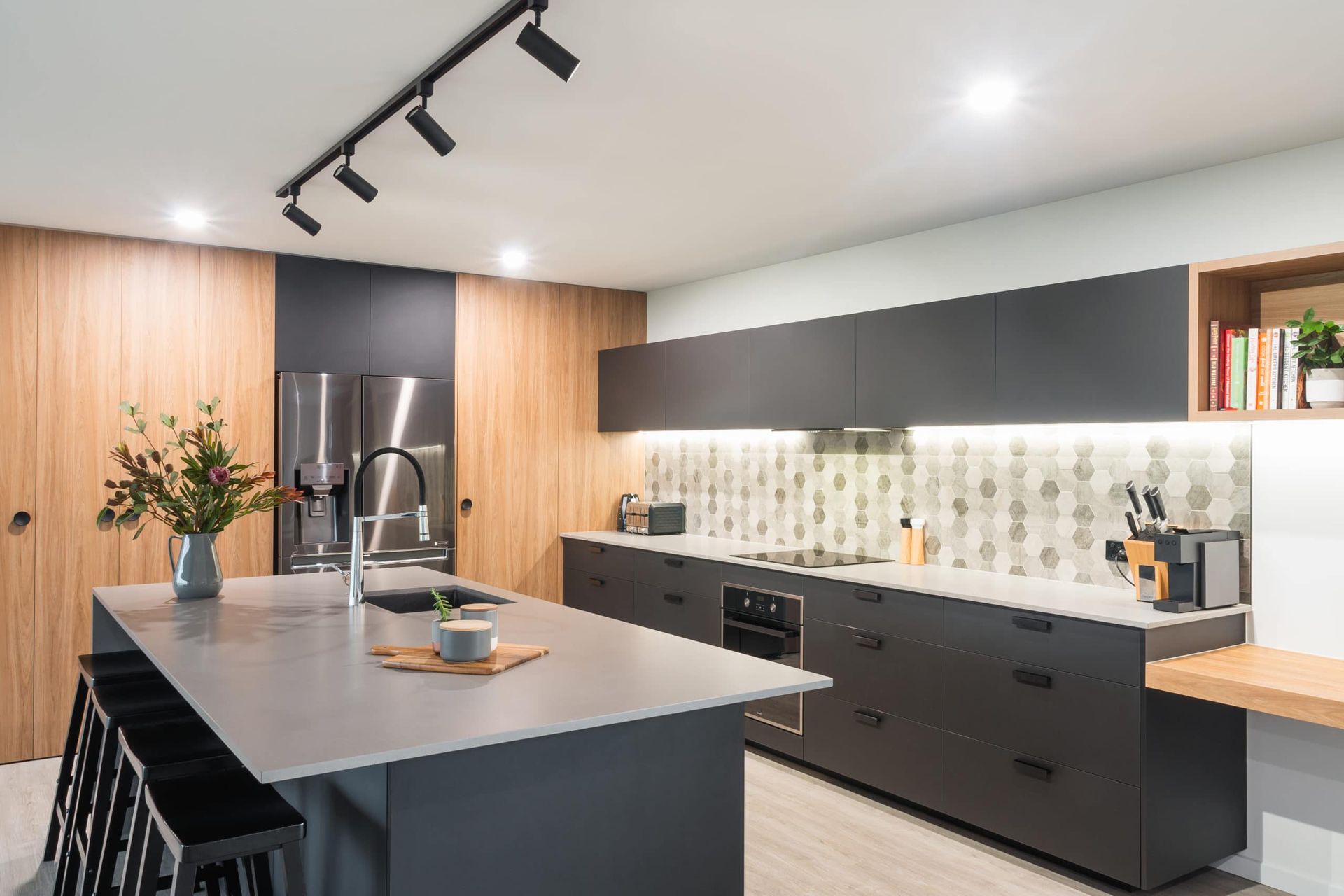 Modern Kitchen With a Gray Island, Black Cabinets, and Light Wood Paneling — Akyrah Kitchens in Gympie, QLD