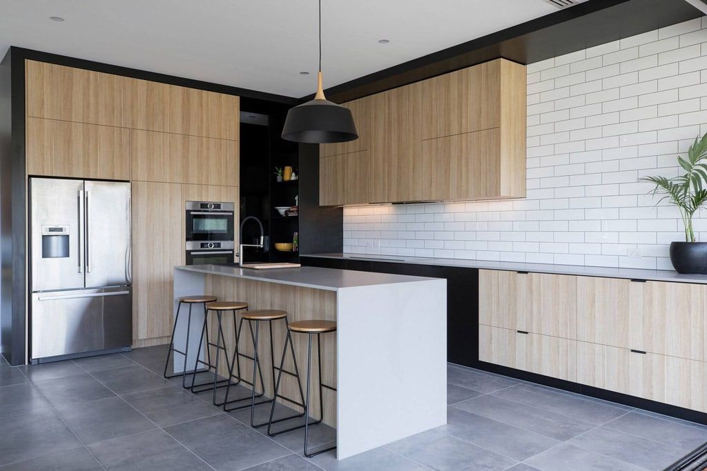 Kitchen With Wood Cabinets, Stainless Steel Appliances, and White Island With Bar Stools — Akyrah Kitchens in Gympie, QLD