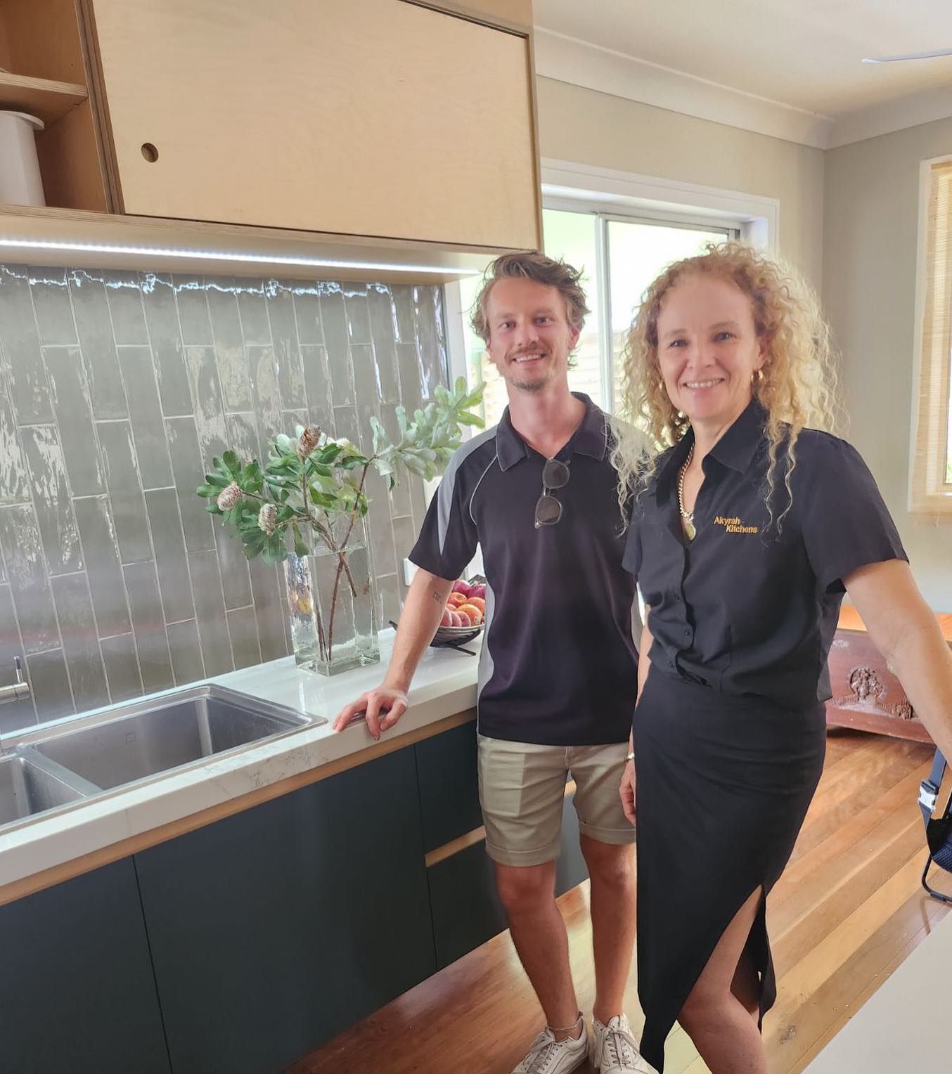 Two People Stand in a Modern Kitchen, Man in Black Shirt and Woman in Black Dress — Akyrah Kitchens in Gympie, QLD