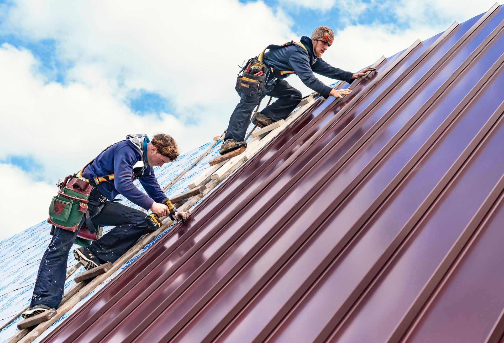 Two men are working on the roof of a building.