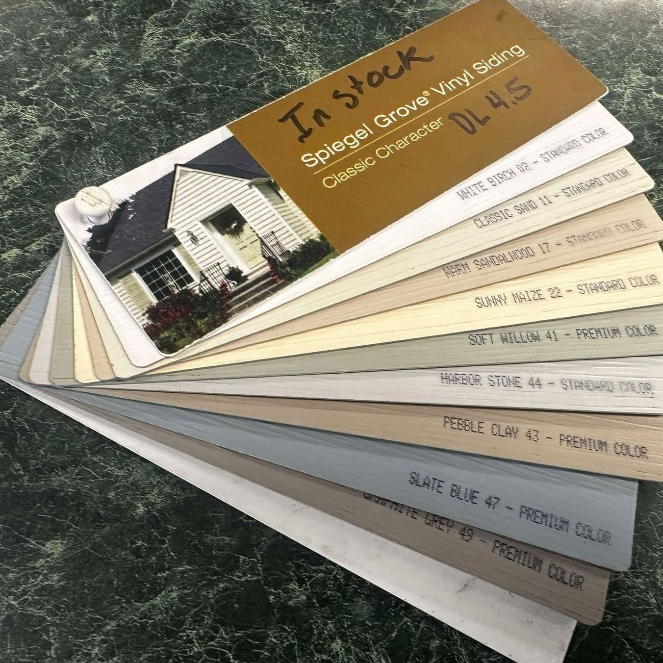 A fan of paint samples with a picture of a house on it.