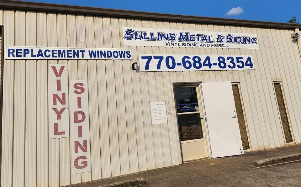 A building with a sign that says replacement windows vinyl siding