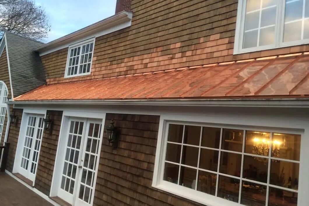 A house with a copper roof and white windows