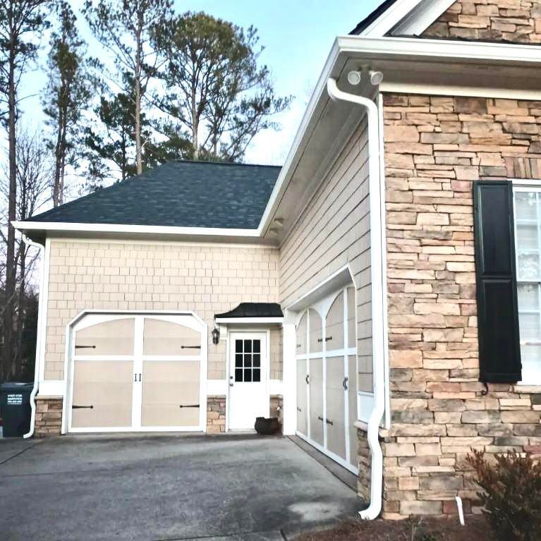 A house with a garage and a brick wall