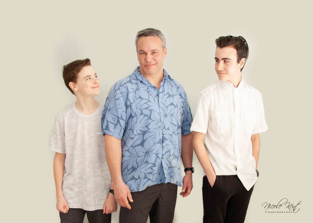 A man and two boys are standing next to each other.