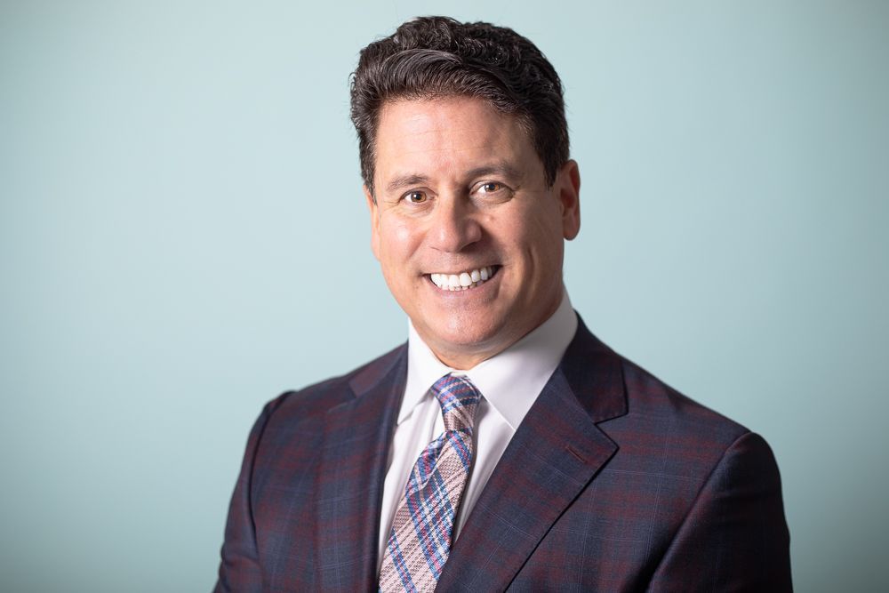 A man in a suit and tie is smiling for the camera.