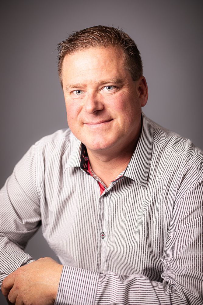 A man in a striped shirt is smiling for the camera.