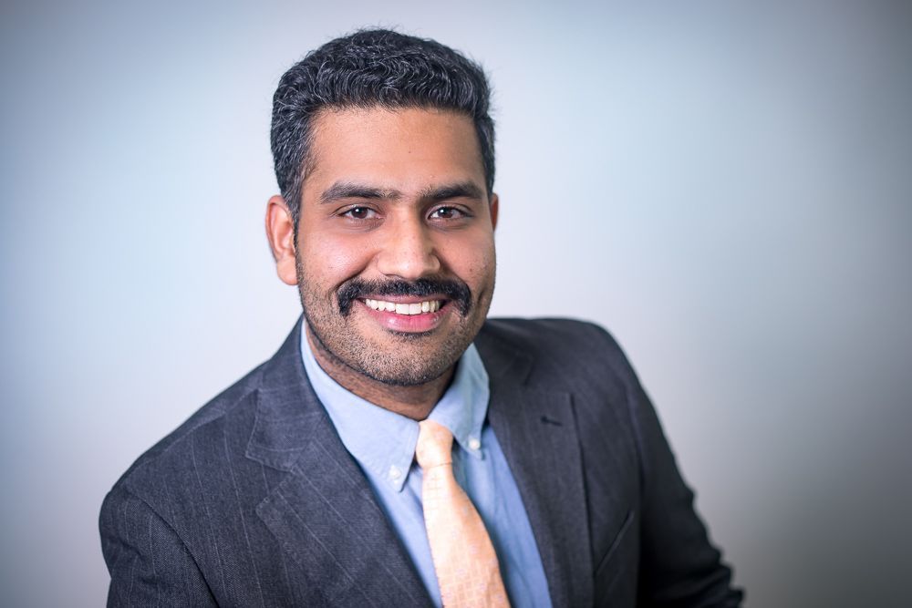 A man in a suit and tie is smiling for the camera.