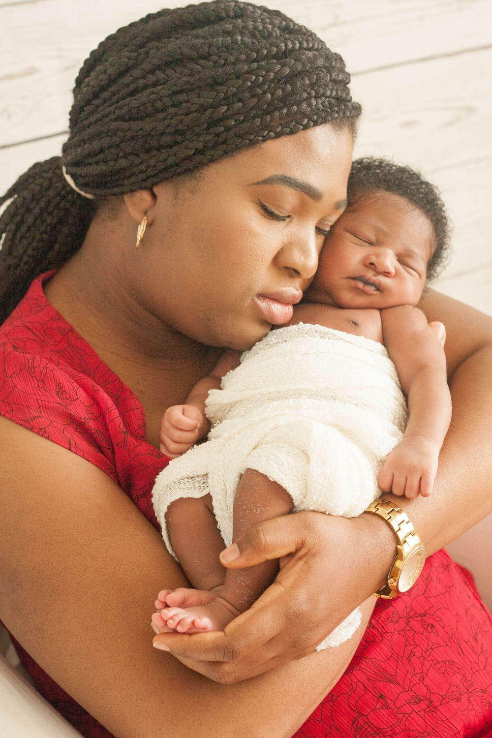 A woman is holding a newborn baby in her arms.