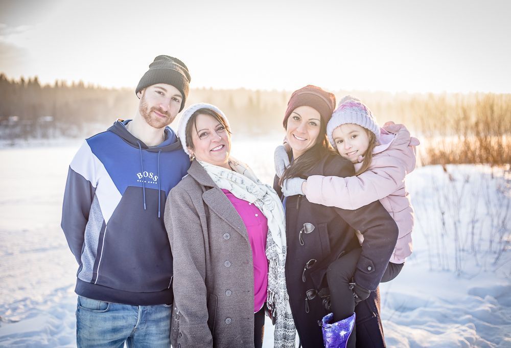 A family is posing for a picture in the snow.