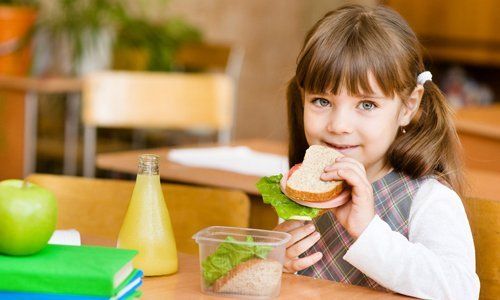 little girl eating a sandwich