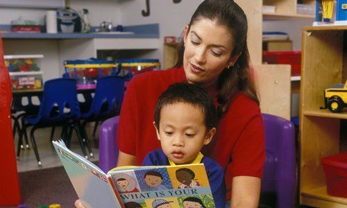 child learning to read with his teacher