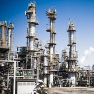 A large industrial plant with a blue sky in the background