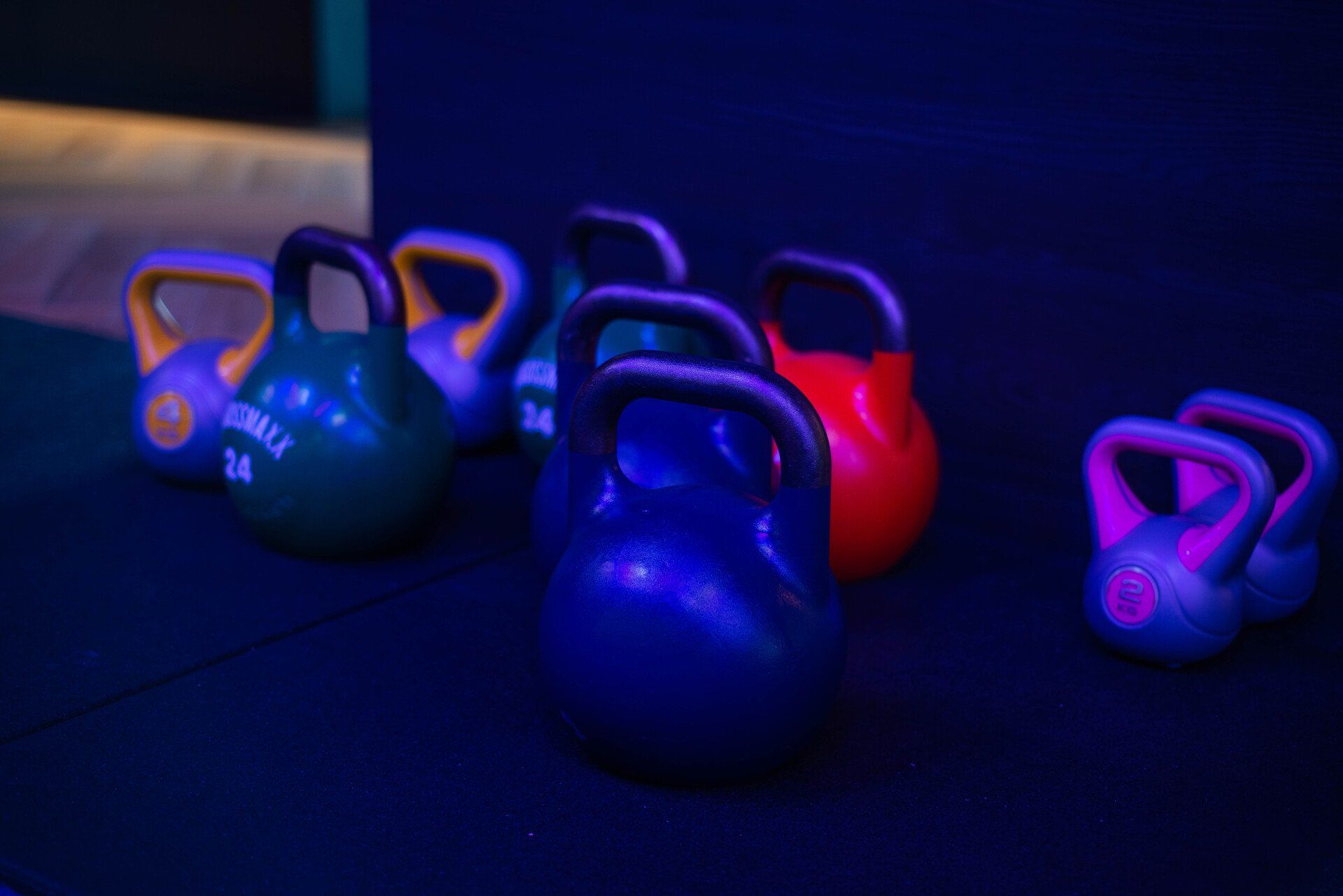 een groep kettlebells zit op een tafel in een sportschool.