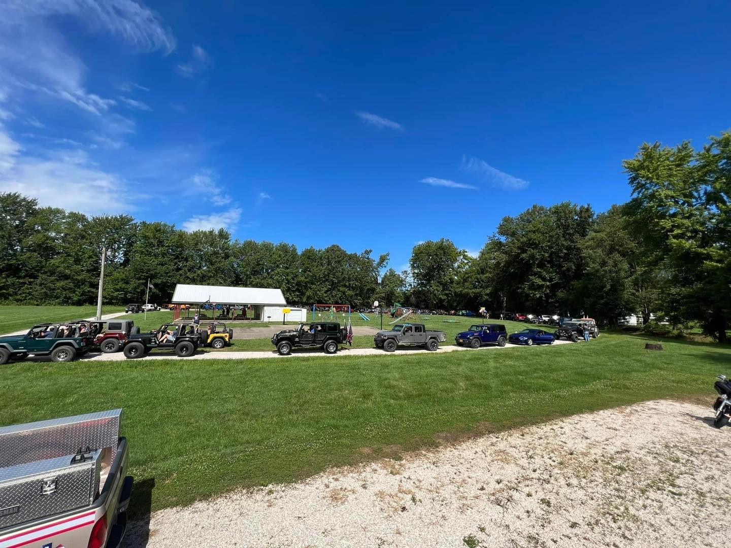 A row of jeep 's are parked in a grassy field.