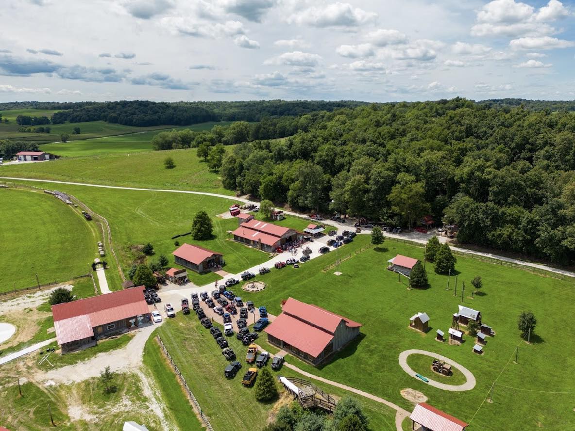 An aerial view of a farm with a lot of buildings and trees.