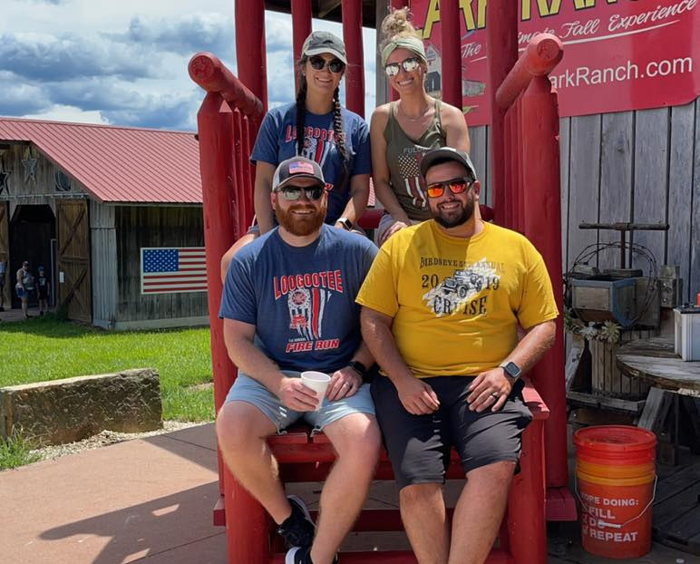 A group of people are sitting on a red chair.