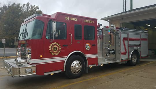 A red fire truck is parked in front of a building.