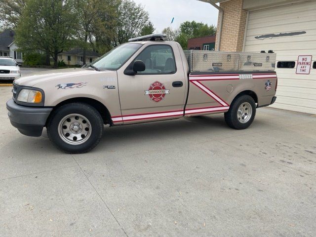 A ford truck is parked in front of a garage.