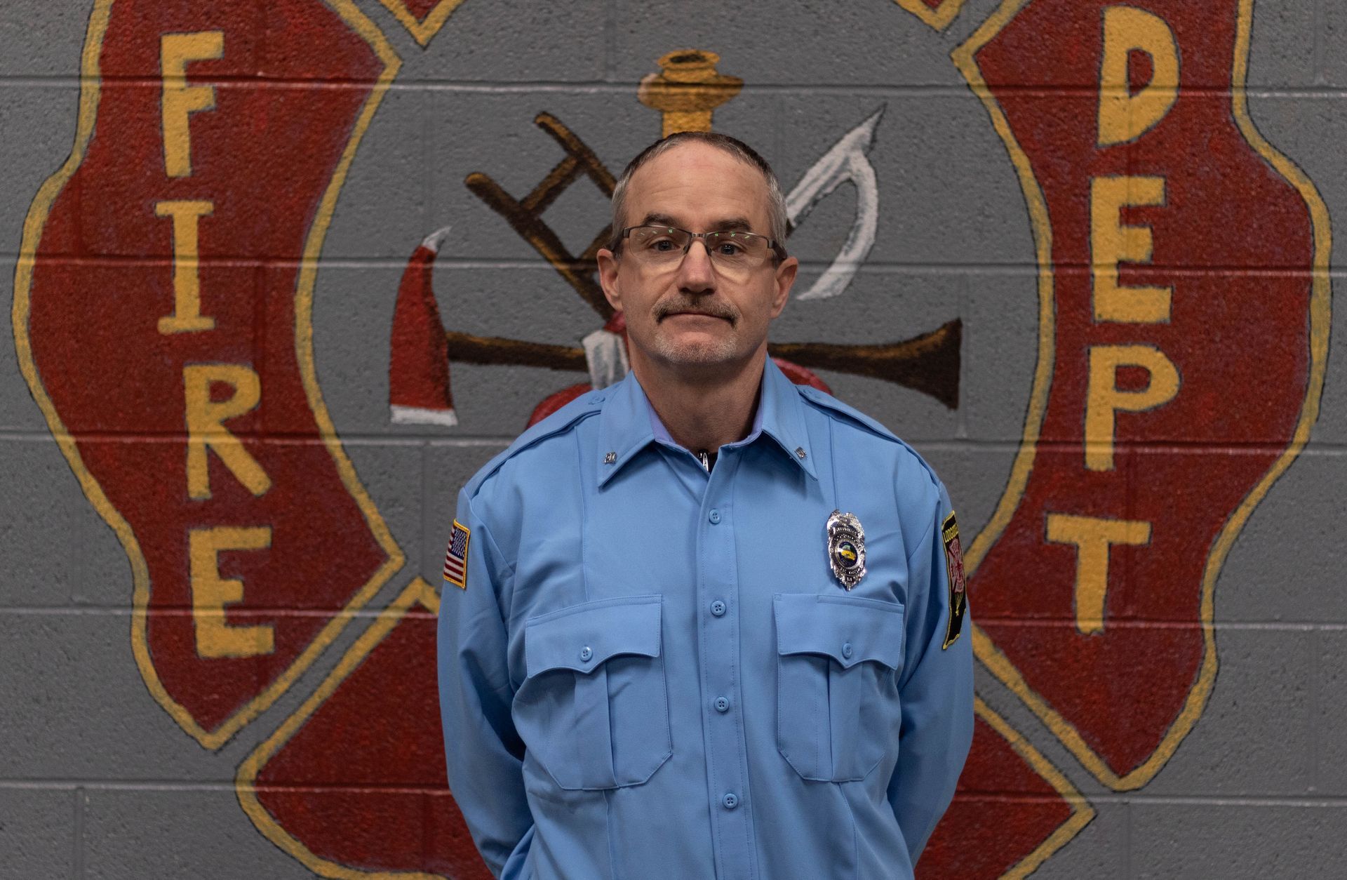 A man standing in front of a fire department logo