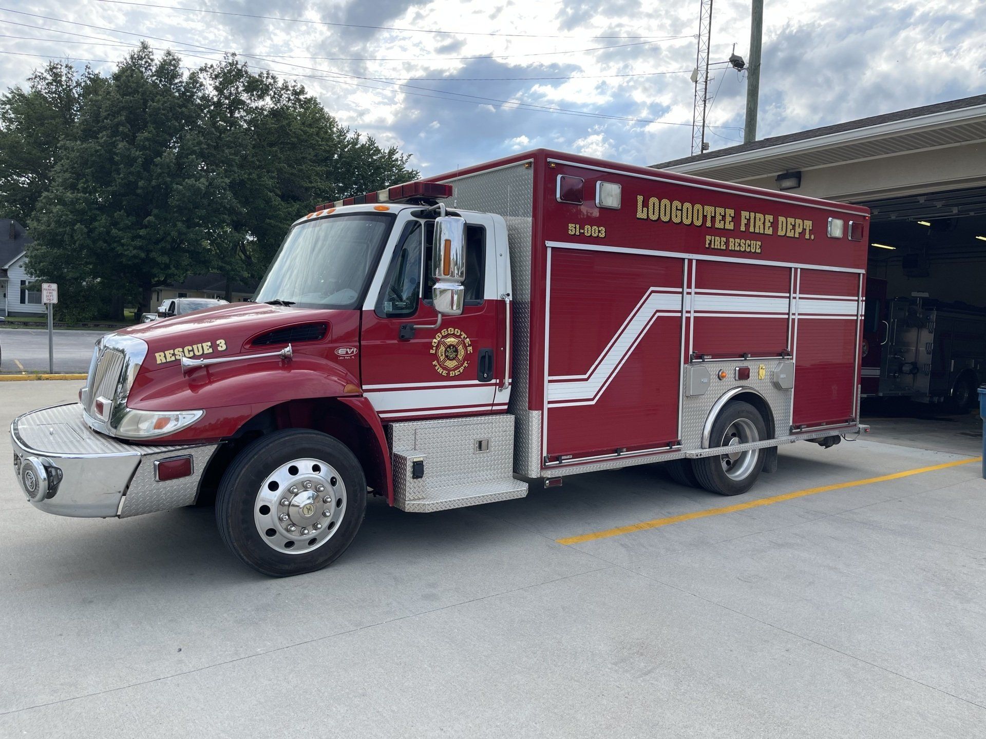 A red and white fire truck is parked in a parking lot.