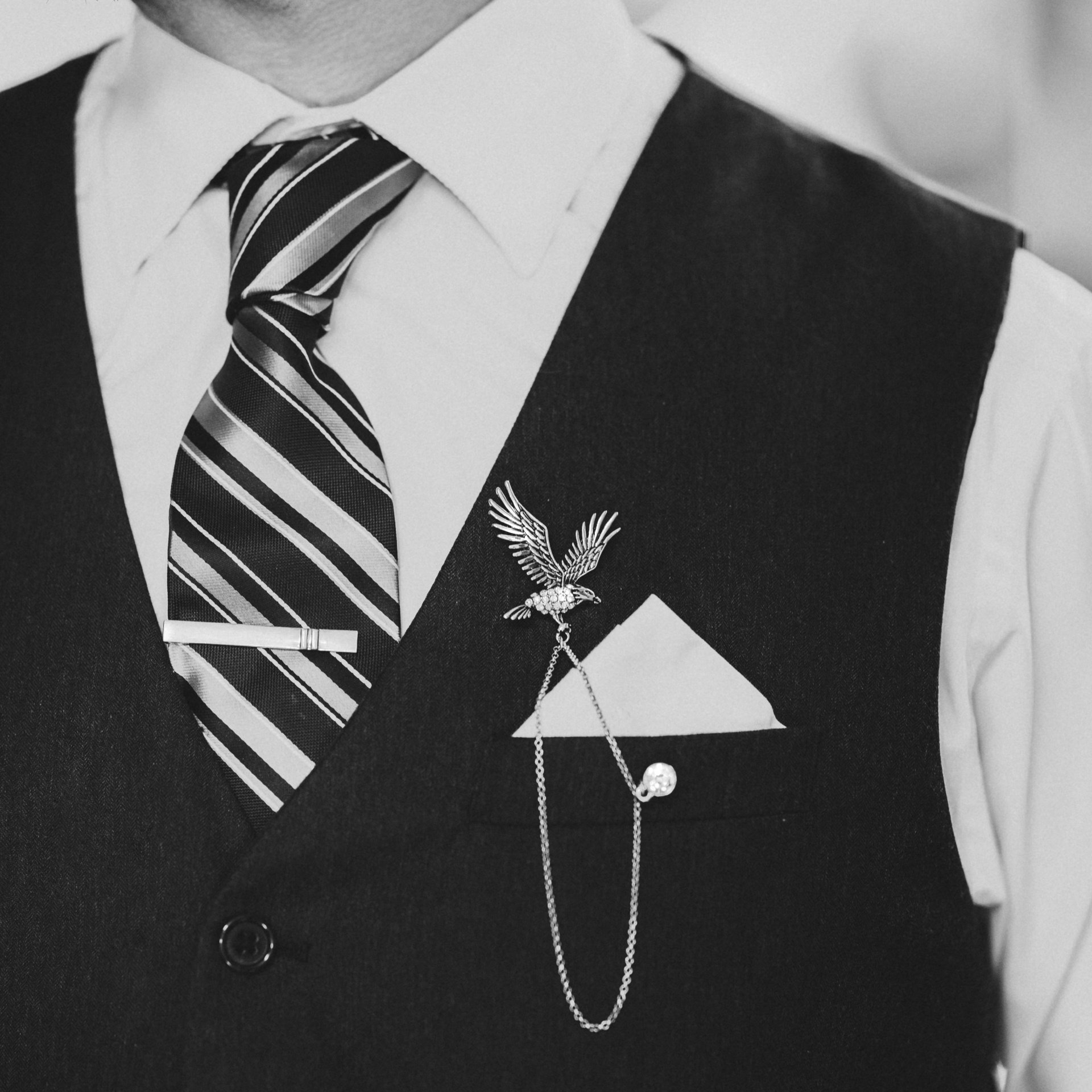 A black and white photo of a man wearing a tie and vest