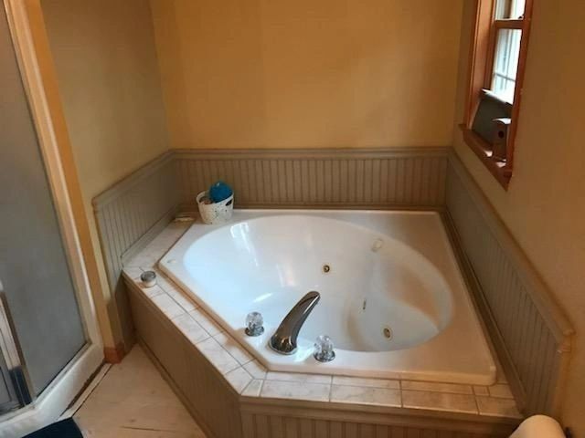A jacuzzi tub in a bathroom next to a window