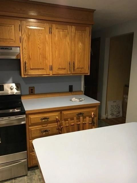 A kitchen with wooden cabinets and a white counter top