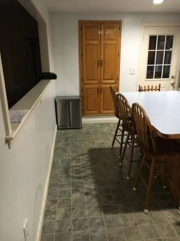 A kitchen with a table and chairs and a window.