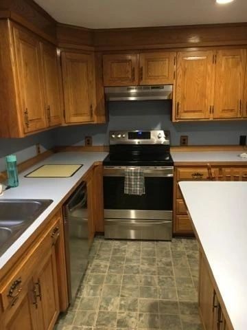A kitchen with stainless steel appliances and wooden cabinets