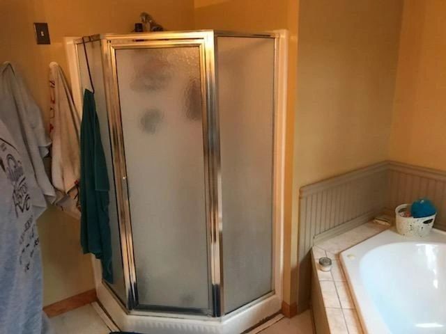 A bathroom with a shower stall and a bathtub.