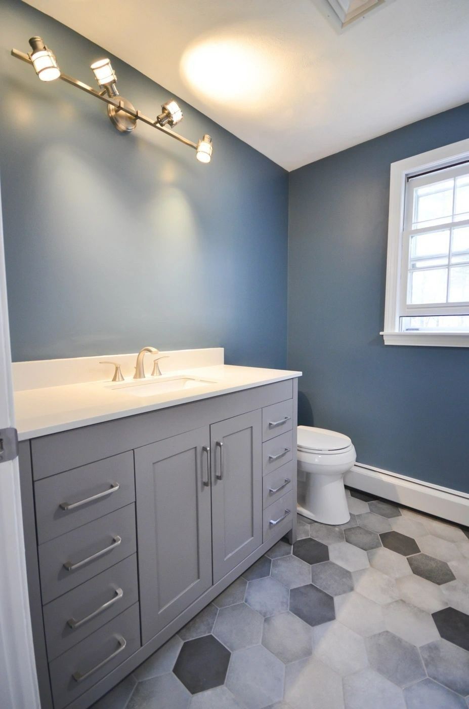 A bathroom with a sink , toilet , and blue walls.