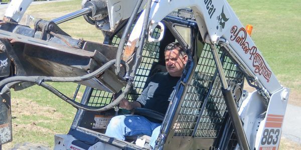 A man is sitting in the driver 's seat of a bobcat 863