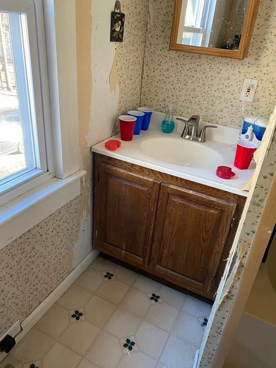 A bathroom with a sink and cups on the counter