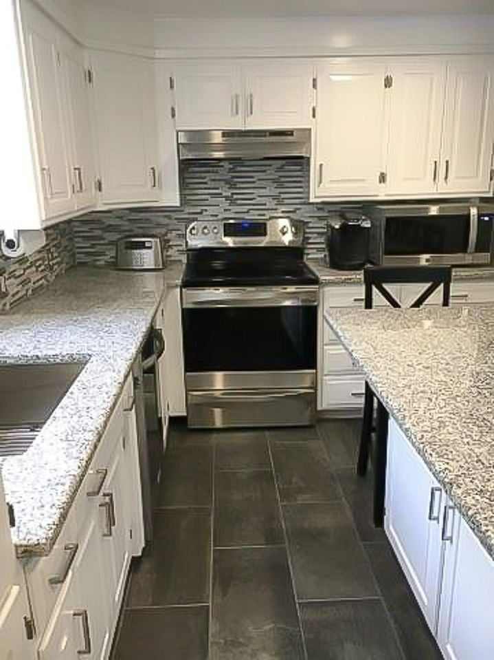 A kitchen with stainless steel appliances and granite counter tops.