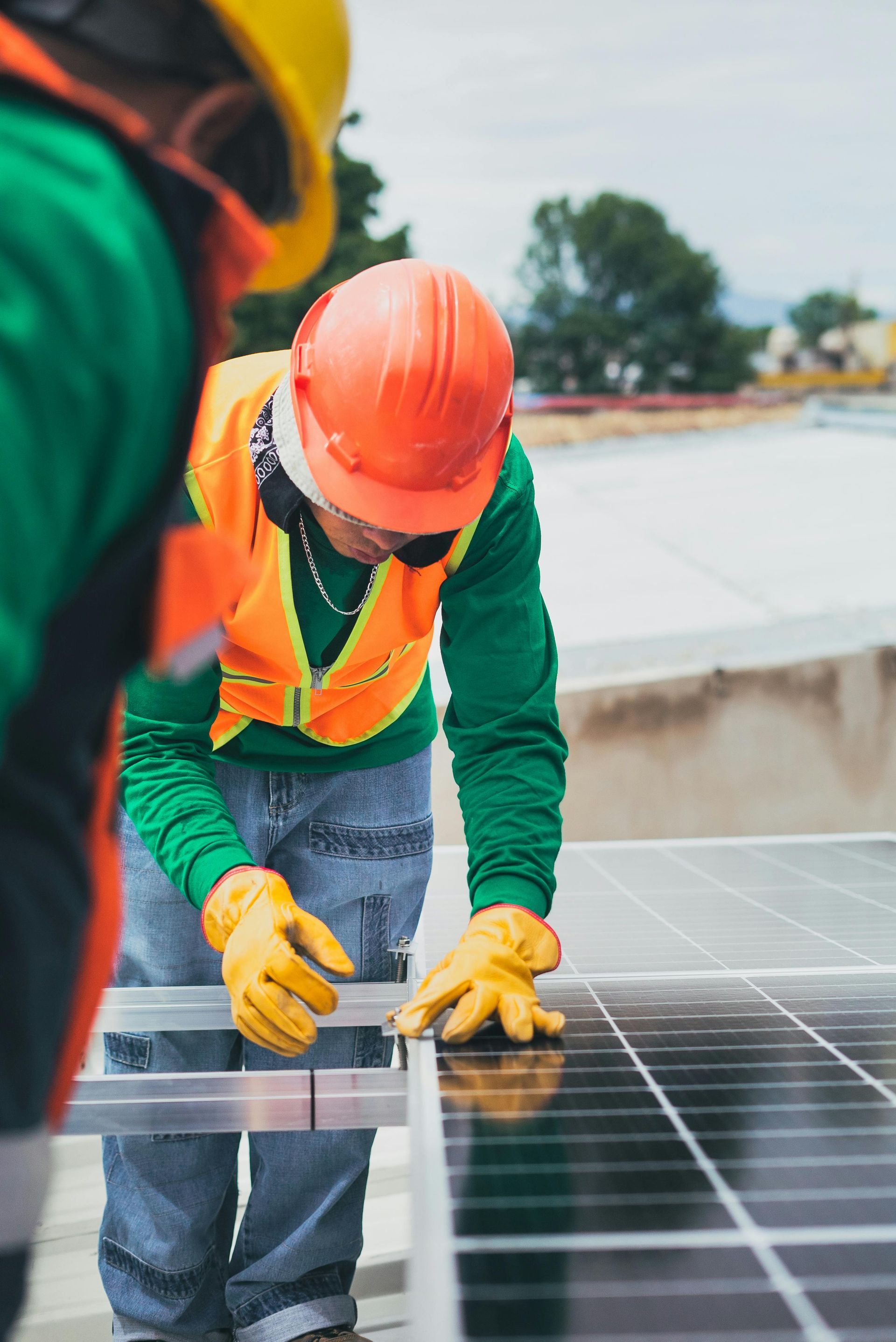 Two men are working on a solar panel on a roof.