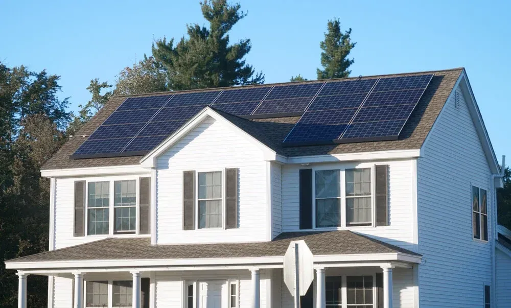 A white house with solar panels on the roof