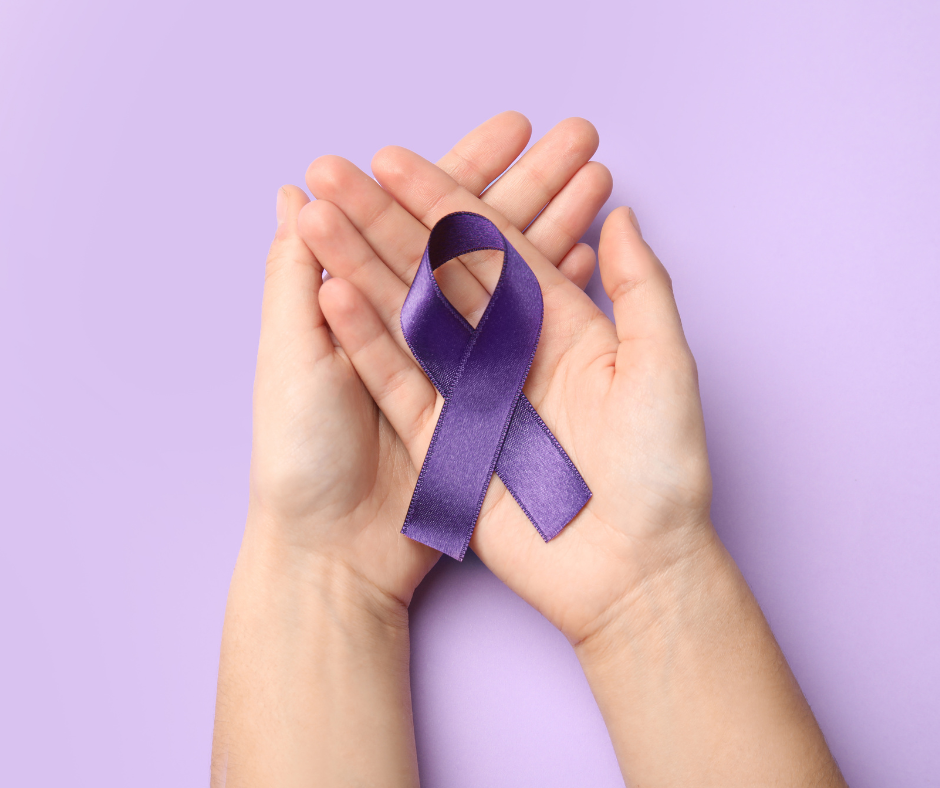 Hands cupping a purple ribbon symbolizing domestic violence awareness