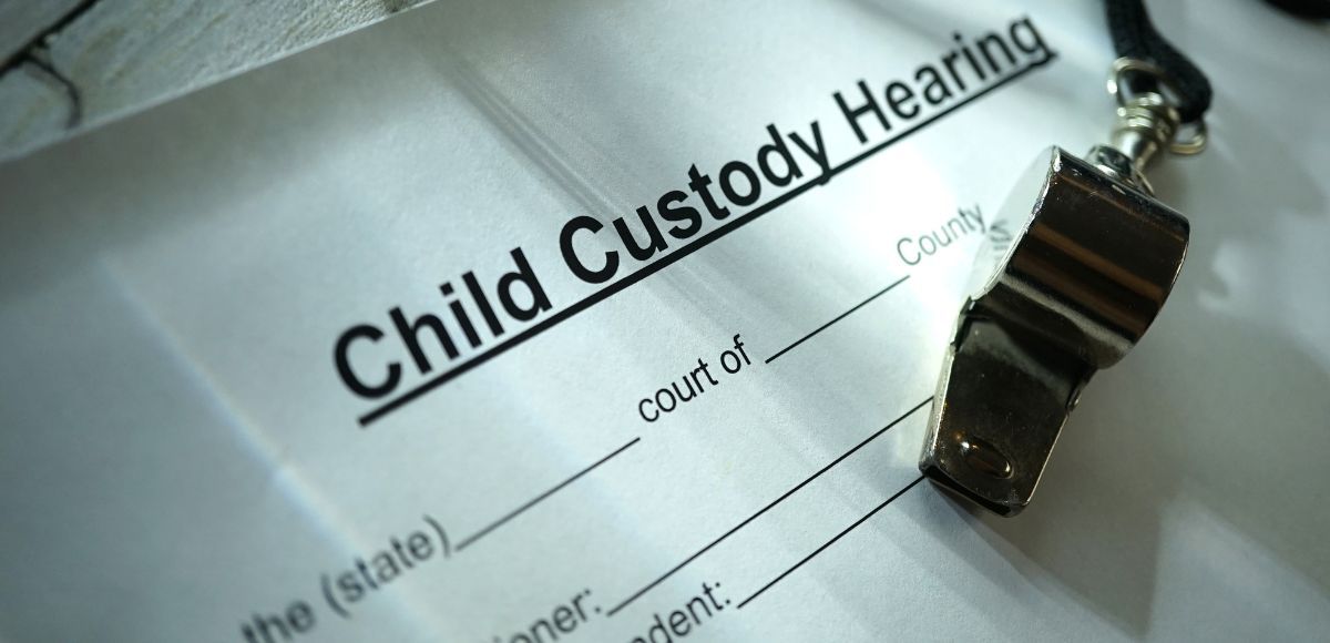 Child custody hearing form with a metal ring binder clip on the page