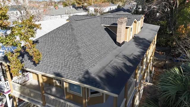 Grey shingle roof on a multi-story building with a balcony.
