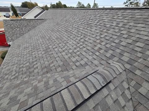 Gray asphalt shingle roof on a house, angled view.