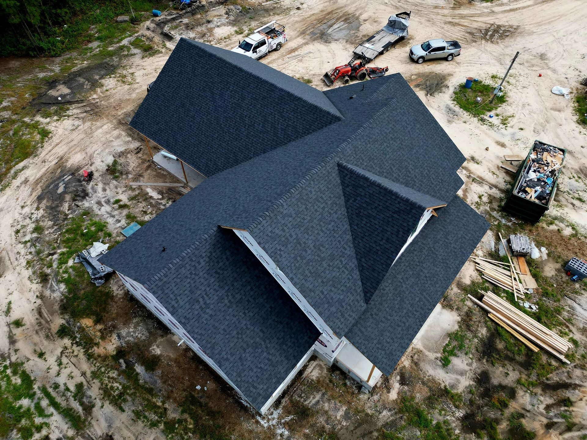 Overhead view of a house under construction with a dark gray shingle roof.